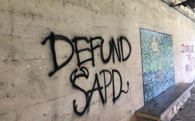 Defund police message spray painted on River Walk wall